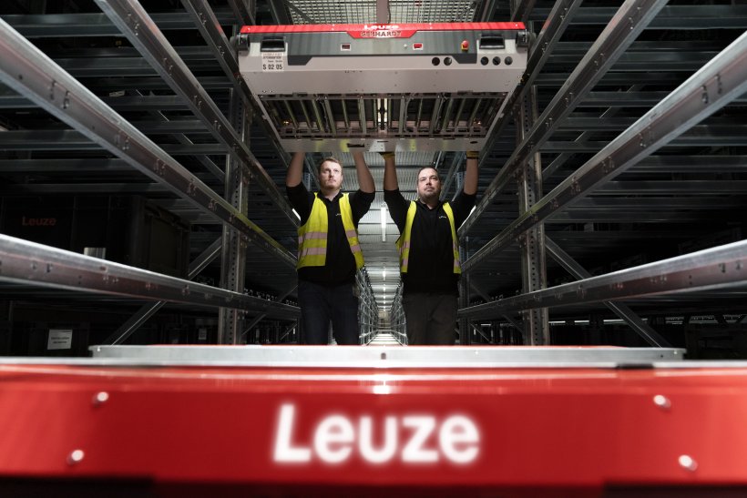 Gelebte Präzision: Zwei der weltweit rund 1.600 „Sensor People“ von Leuze prüfen im firmeneigenen Distributionszentrum ein Shuttle für die Intralogistik.